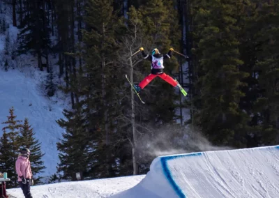 skier doing a spread eagle on a slope jump at norquay