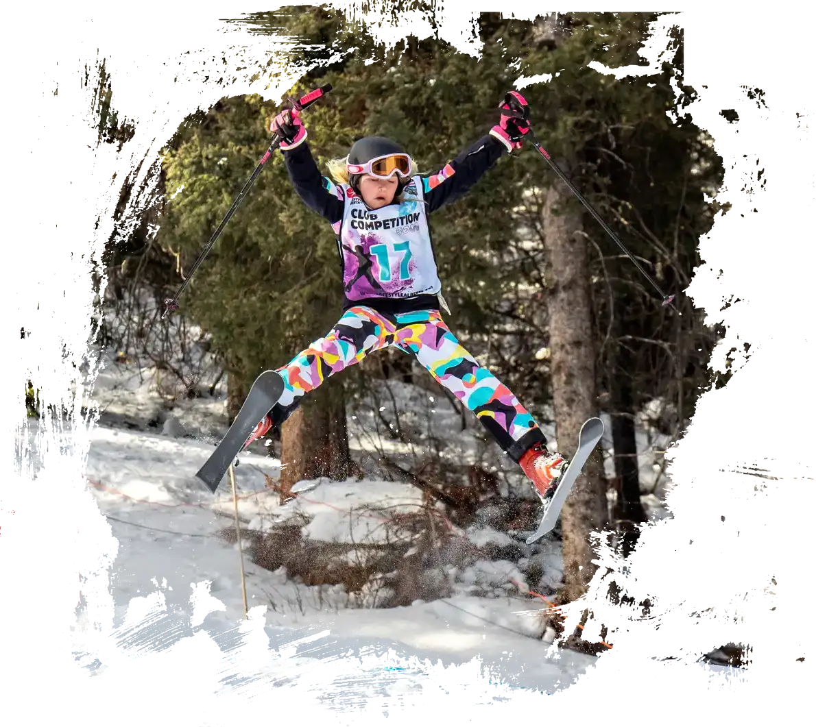 skier doing a spread on a mogul jump at norquay