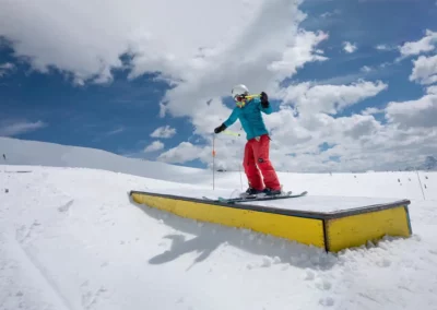 Young freestyle skier sliding across a box